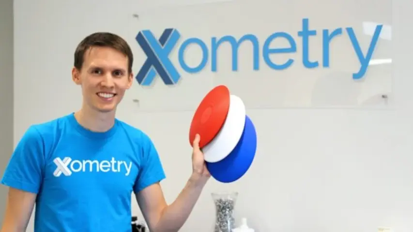 Greg Paulsen of Xometry holding what looks to be 3D printed frisbes.